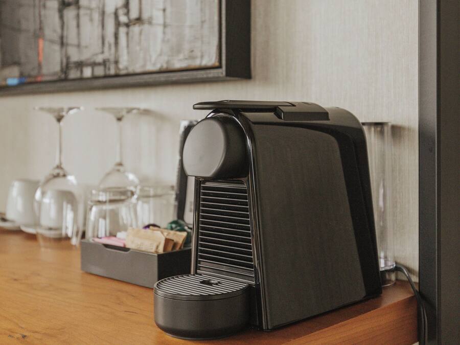 A coffee machine on a wooden counter with a coffee maker and a box of tissues.