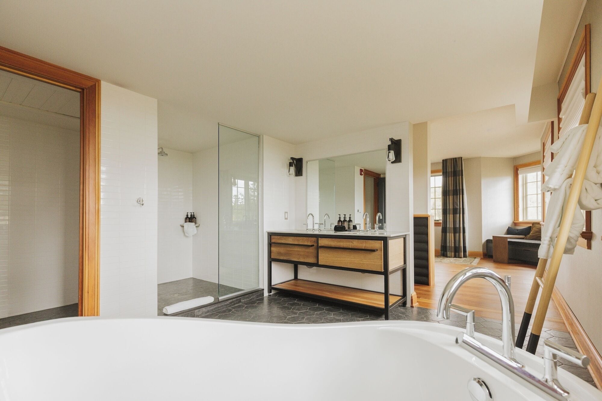 Un baño moderno con bañera, ducha y tocador con espejo.