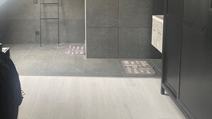 A modern bathroom with dark tiles, a wooden floor, and a skylight. - Villa Lumina Royale With Swimming Pool (Zutendaal)