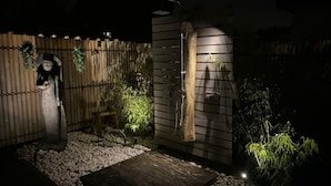 A private garden with a wooden fence, a stone pathway, and a small wooden deck. - Villa Lumina Royale With Swimming Pool (Zutendaal)