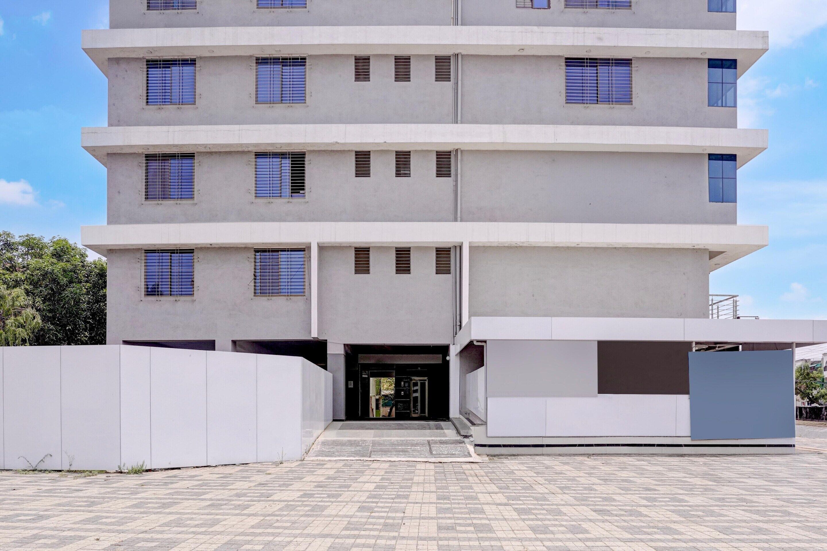 A multi-story building with a flat facade, large windows, and a gated entrance.