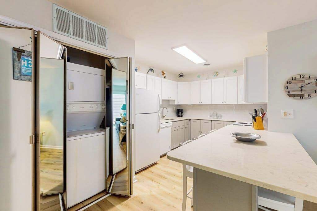 A compact kitchen with white cabinets, a built-in oven, and a small countertop.