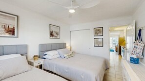 A bedroom with two beds, a nightstand, a bedside table, and a ceiling fan. - Beautiful Ocean view Condo short walk to the beach access (Ocean City)