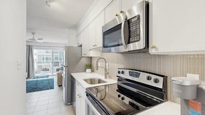 A modern kitchen with stainless steel appliances, a built-in oven, and a coffee maker. - Beautiful Ocean view Condo short walk to the beach access (Ocean City)