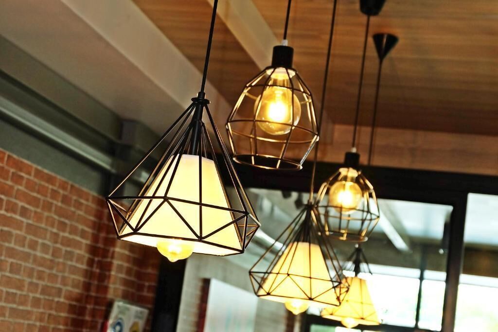 Suspensions lumineuses aux motifs géométriques, suspendues au plafond.
