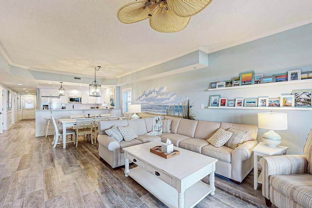 A spacious living area with a sofa, coffee table, and a dining table.