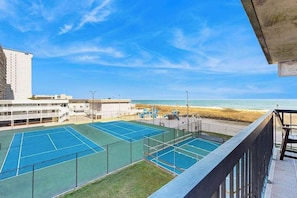 A tennis court with a view of the beach and ocean. - Beach condo with balcony, indoor/outdoor pools, game room & gym (Ocean City)