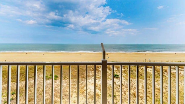 A beach view with a wooden fence in the foreground. - Calypso 406 (Ocean City)