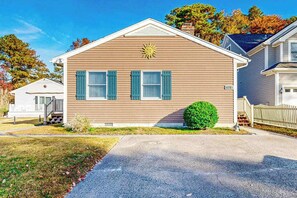 A single-story house with a brown siding exterior, a front porch, and a small front yard. - 416 - 141st St (Ocean City)