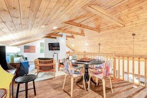 Un interno in legno con zona pranzo, televisore e una bandiera.