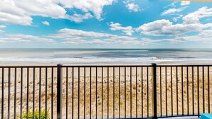 En balkong med utsikt över stranden och havet.