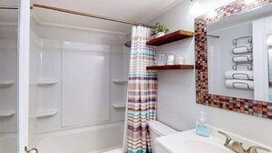 A bathroom with a shower, a toilet, a sink with a mirror, and a towel rack. - Ocean Waye 226 (Ocean City)