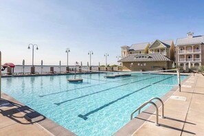 A swimming pool with multiple lanes, a lifeguard stand, and a building with balconies. - Sunset Island - 57 & 59 Island Edge (Ocean City)