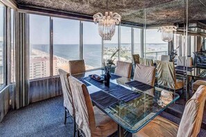 A high-rise room with a glass table, leather chairs, and a view of the ocean. - 20th-floor beachfront condo with ocean views, indoor/outdoor pools, & gym (Ocean City)
