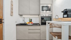 Una cocina moderna con horno, microondas y pileta de acero inoxidable.