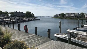 Un port de plaisance avec des bateaux amarrés, une jetée en bois et des bâtiments en arrière-plan.