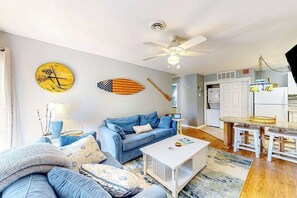 Ein Wohnzimmer mit Sofa, Couchtisch und Deckenventilator.