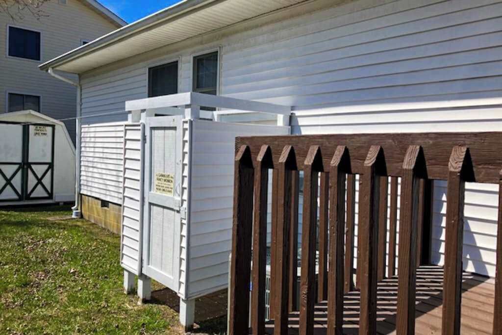 A mobile home with a wooden deck and a white exterior.