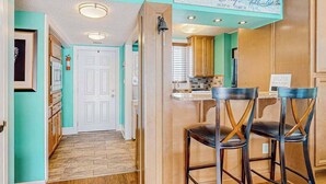A kitchen with wooden cabinets, a white door, and a sign that reads 'Ocean City.' - Wight Bay North 439 (Ocean City)
