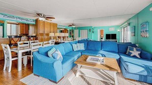 A living room with a blue sofa, wooden dining table, and chairs. - Wight Bay North 439 (Ocean City)