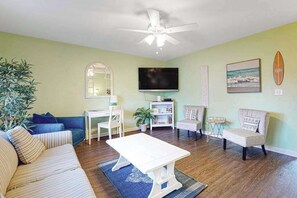 A living room with a sofa, coffee table, TV, and a ceiling fan. - Large duplex w/2 separate homes, two kitchens, patio, WiFi, & great location (Ocean City)
