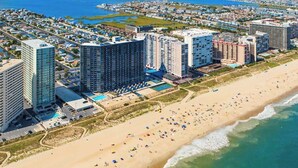 Un hôtel situé sur la côte, composé de plusieurs immeubles de grande hauteur, et doté d’une plage et d’un espace piscine.
