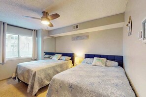 A bedroom with two beds, a ceiling fan, and a window with blinds. - Jamaica Bay 202B (Ocean City)