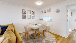 Ruokailutila, jossa on pyöreä pöytä, tuoleja ja kuviollinen matto.