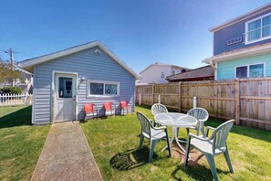 A small house with a front door, a window, and a patio with a table and chairs. - Cute Ocean City single family home with Central AC & W/D (Ocean City)