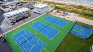 Ein mehrgeschossiges Gebäude mit einem Tennisplatzkomplex.