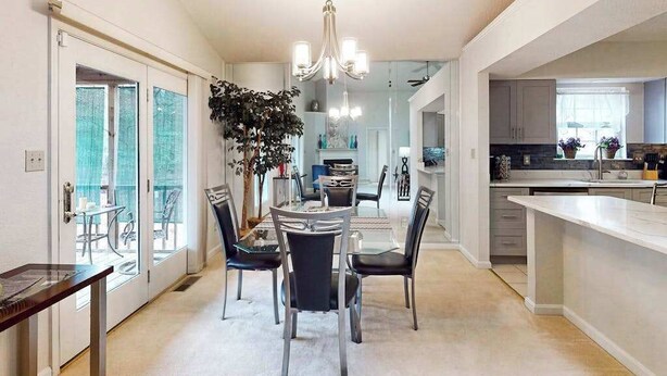 A modern kitchen with a central island, a dining area with a round table and chairs, and a large plant in the middle. - 22 Harpoon Rd (Ocean Pines)