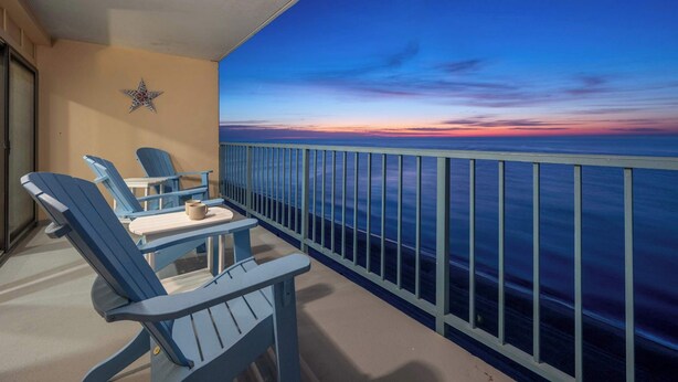 Ein Balkon mit zwei Adirondack-Stühlen, einem kleinen Tisch und einem dekorativen Stern an der Wand.