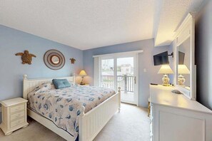 A bedroom with a bed, bedside tables, a dresser, a TV, and a balcony door. - Sunny Ocean block condo with balcony, AC, WiFi & laundry - walk to the beach (Ocean City)