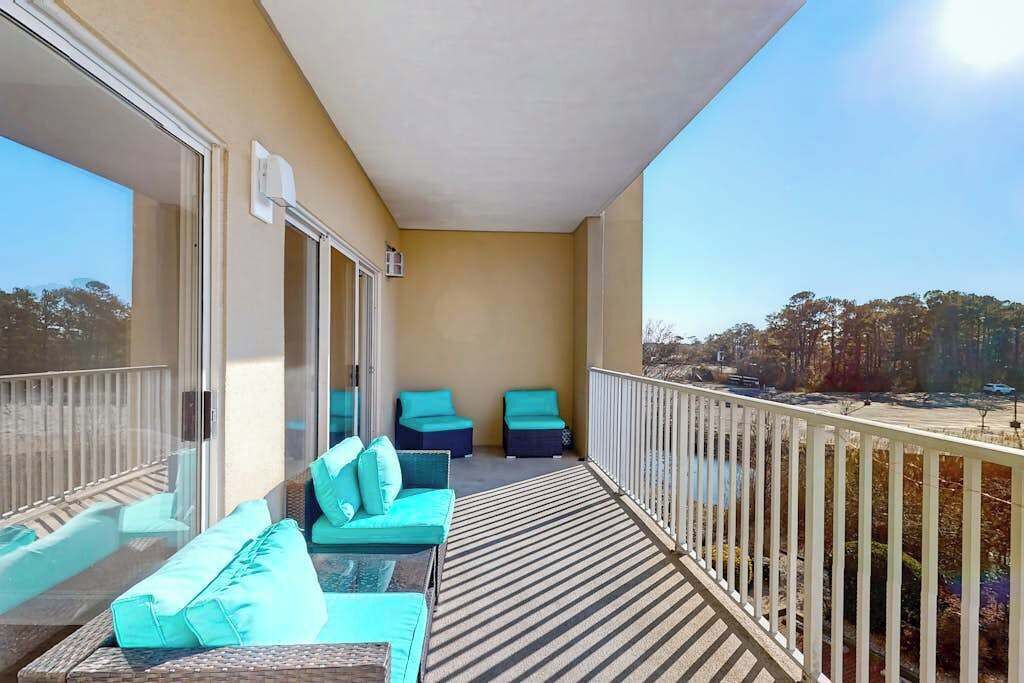 Un balcon avec vue, un canapé et deux fauteuils.