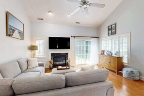 A living room with a sofa, a fireplace, a television, and a ceiling fan. - River Run 135 (Berlin)