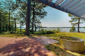 A paved pathway leading to a body of water, surrounded by trees and a covered area. - Marina Dr 11347 (Berlin)