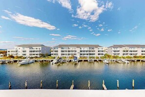 Ein Hotel am Wasser mit mehreren Gebäuden, angestaubten Booten und blauem Himmel.