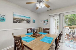 A dining area with a wooden table, blue placemats, and chairs. - Beach Retreat (Ocean City)