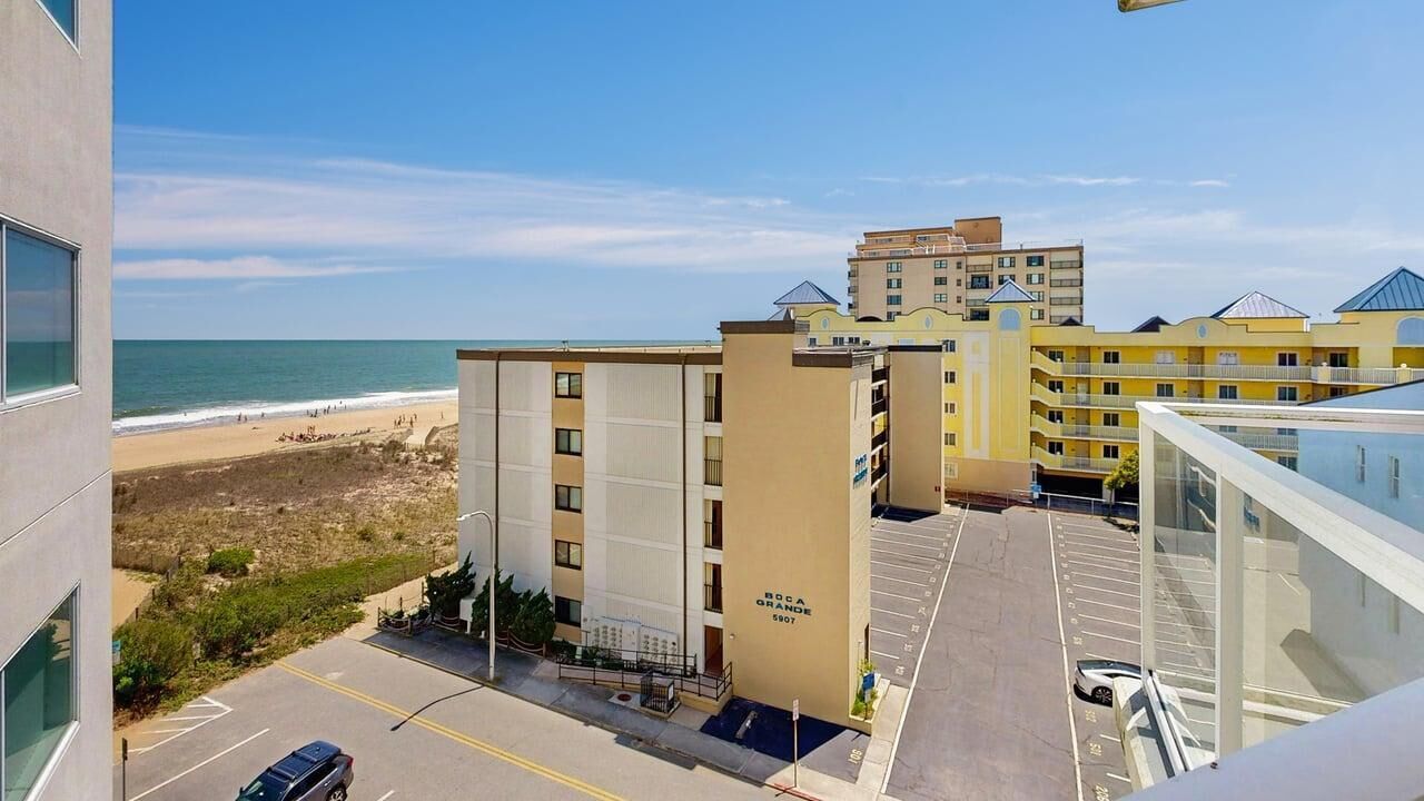 Un hôtel doté d’un parking, offrant une vue sur la plage, et dont le bâtiment porte une enseigne indiquant « Boca Grande 5807 ».