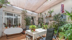 A patio with a table and chairs, surrounded by potted plants and a large umbrella. - Vacation Apartment 'Casa Tesalia' with Sea View, Wi-Fi and Air Conditioning (Güímar)