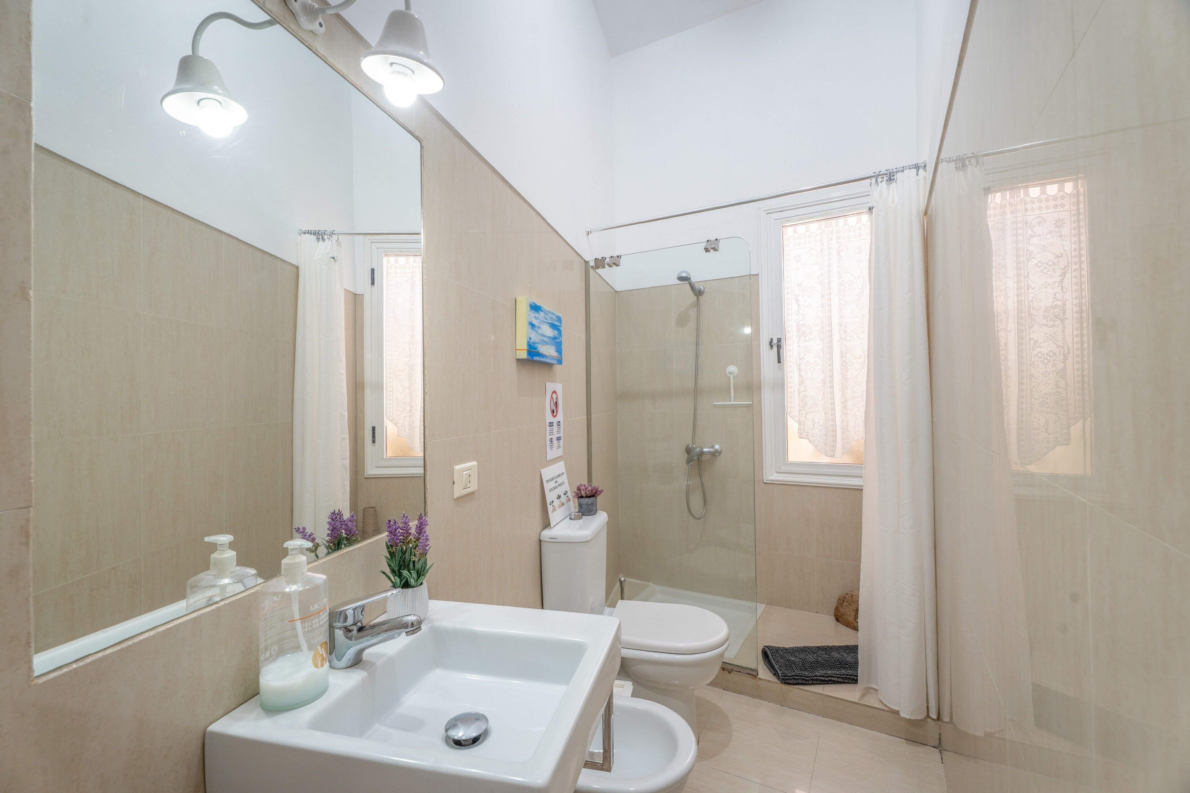 Un bagno con lavandino, WC e doccia.