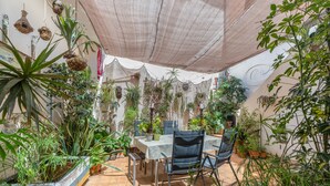 A covered patio with a table and chairs, surrounded by various potted plants. - Vacation Apartment 'Casa Tesalia' with Sea View, Wi-Fi and Air Conditioning (Güímar)