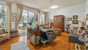 A spacious living room with a sofa, armchair, wooden cabinet, and a bookshelf. - Vacation Apartment 'Casa Tesalia' with Sea View, Wi-Fi and Air Conditioning (Güímar)