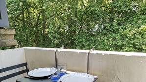 A balcony with a table set for two, two plates, two glasses, and a fork. - Studio in the center of Toulouse, 7 minutes by bike from Place Saint Pierre (Toulouse)