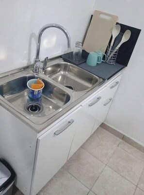 Una cocina con un lavamanos doble, una encimera y un armario.