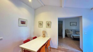 A room with a dining table, chairs, a lamp, and a sofa. - Villa Caroubier - A peaceful stay just a stone's throw from the sea (Zonza)