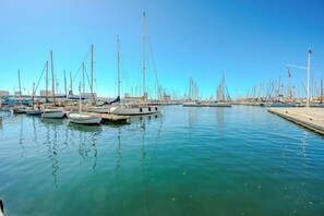 Ein Yachthafen mit mehreren angedockten Booten, ruhigem Wasser und blauem Himmel.
