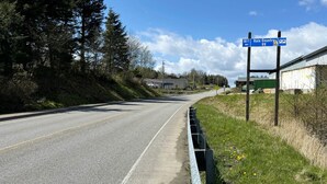 A road with a blue directional sign indicating Rain Country RV and a distance marker of 500 feet.