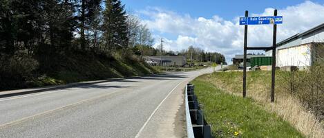 A road with a blue directional sign indicating Rain Country RV and a distance marker of 500 feet.