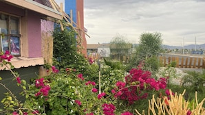 A building with a purple facade, a blue and red structure, and a garden with pink flowers. - Magic ArtHouse at the heart of Las Vegas 
Near everything (North Las Vegas)